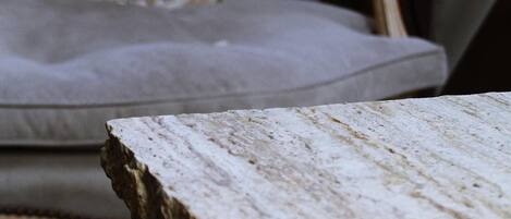 Primer plano de una superficie de mármol con una silla al fondo.