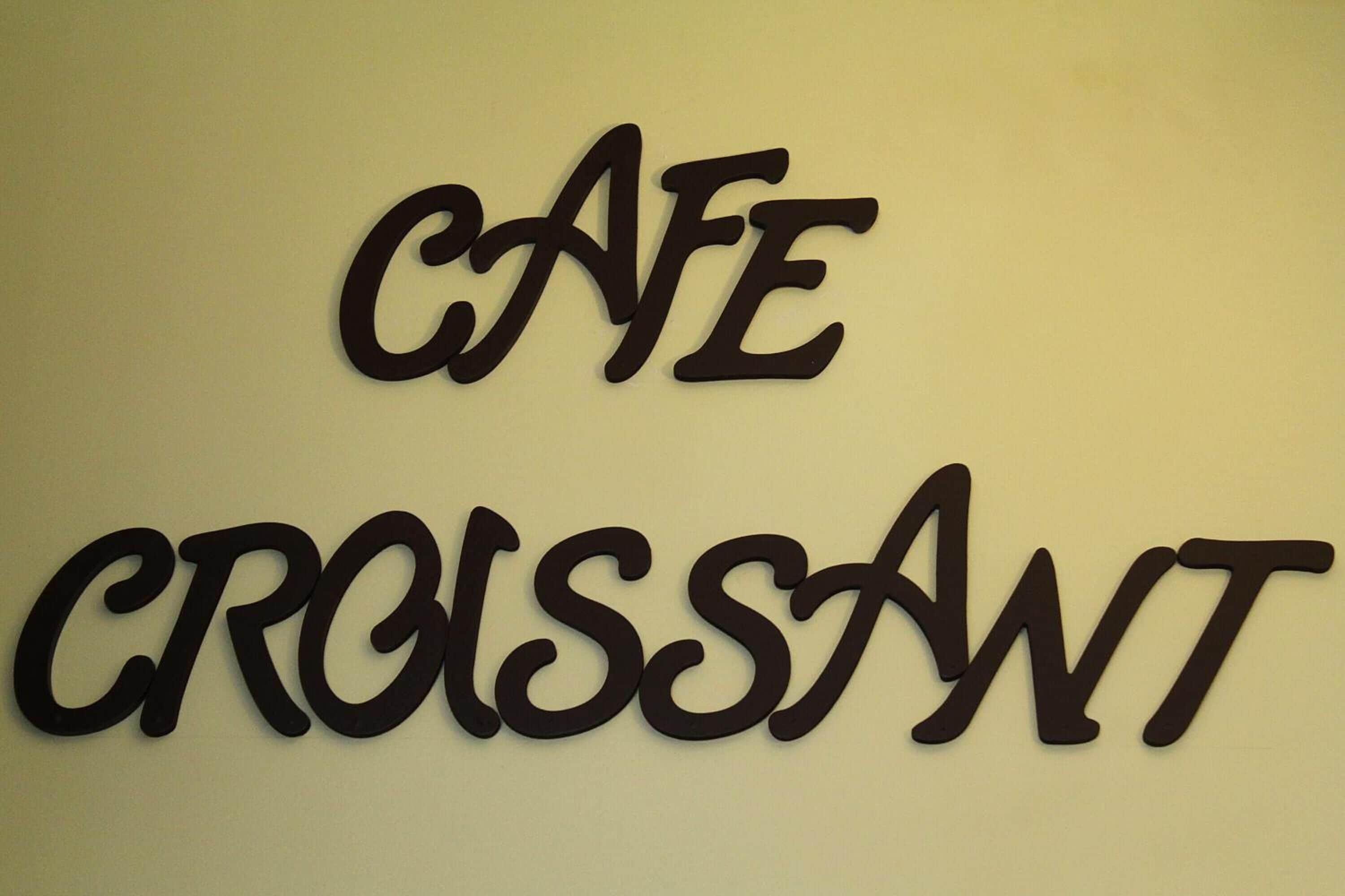 A wall with the words "Café Croissant" in large, bold letters.
