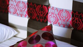 Una cama con un almohadón estampado con lunares.