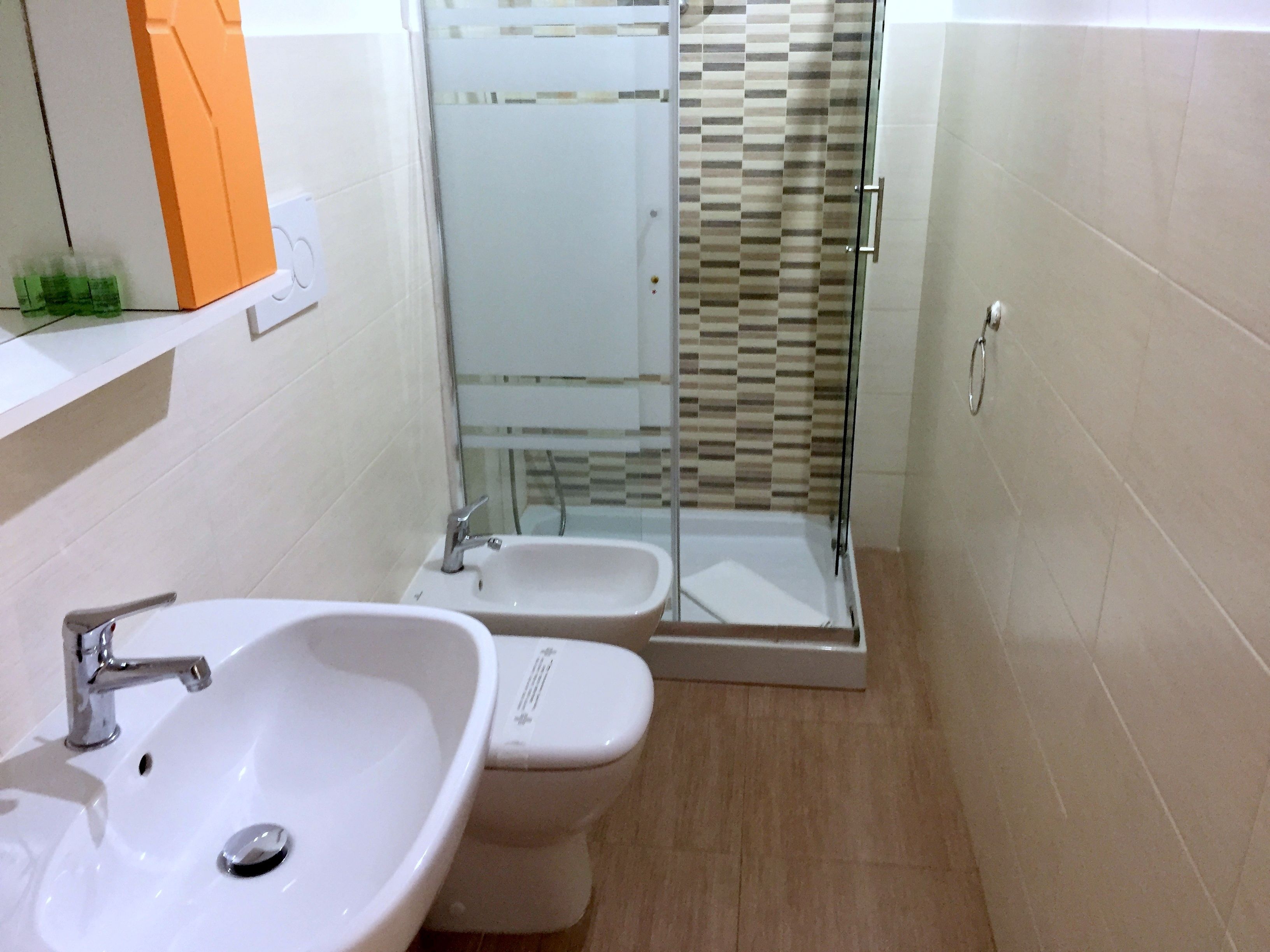 A bathroom with a sink, toilet, and glass-enclosed shower.