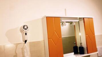 A bathroom with a white wall, a white sink, a mirror, and a towel rack.