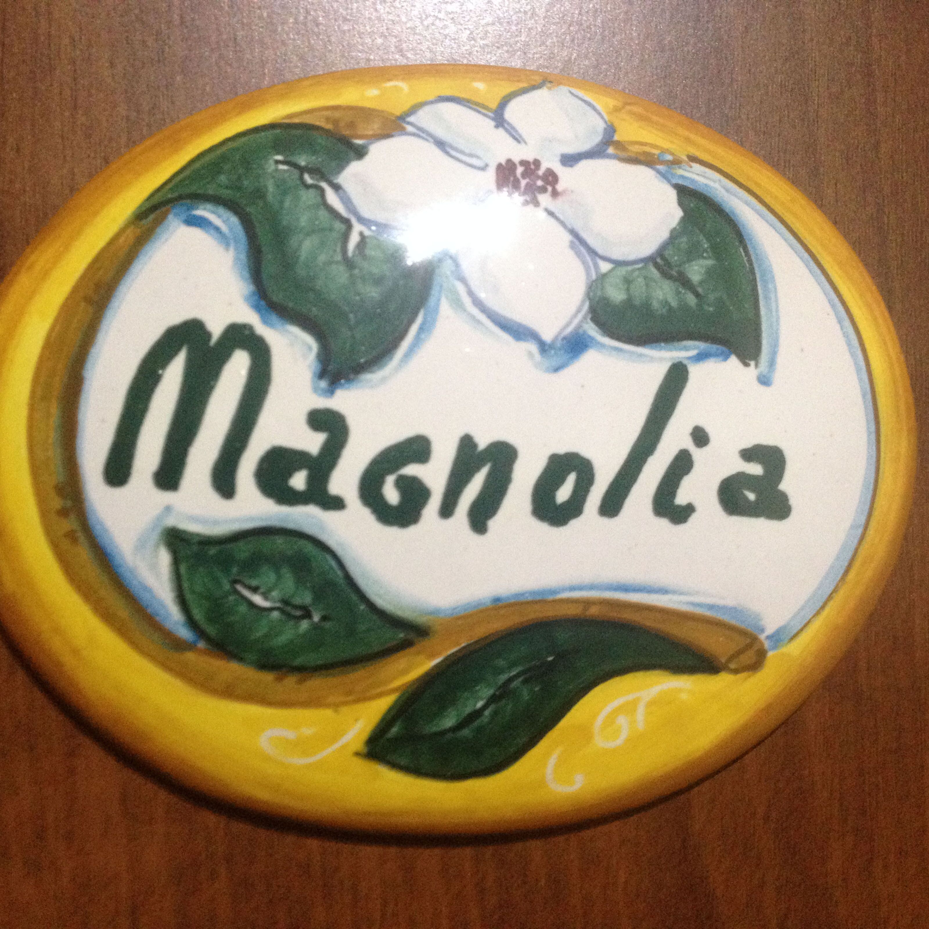 A decorative plate with the word "Magnolia" and floral designs.