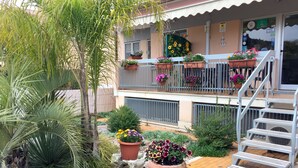 A building with a balcony adorned with potted plants and flowers. - Il Giardino di Adriana (Terracina)