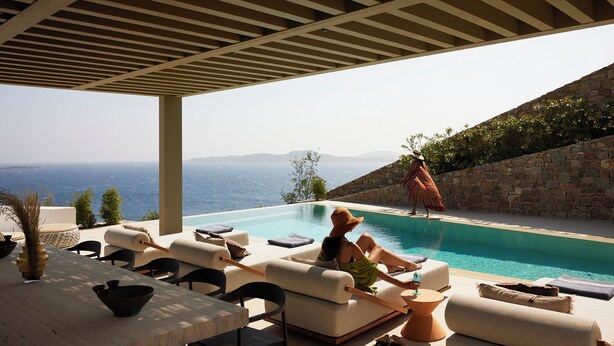 A poolside area with lounge chairs and a view of the sea. - The Coast Bill&Coo - Adults Only (Mykonos)