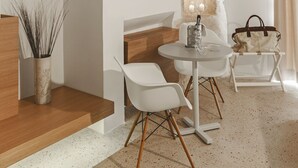 A modern interior with a stone arch ceiling, a round table with chairs, a wooden bench, and a potted plant. - La Dimora di Metello (Matera)