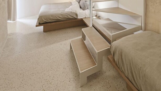 A modern bedroom with a unique arched ceiling, a minimalist staircase, and a bed with a wooden platform. - La Dimora di Metello (Matera)