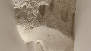 A narrow, white-walled corridor with a speckled floor, leading to a distant archway. - La Dimora di Metello (Matera)