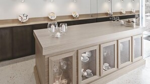 A modern kitchen with a wooden island, pendant lights, and a view of the outdoors. - La Dimora di Metello (Matera)