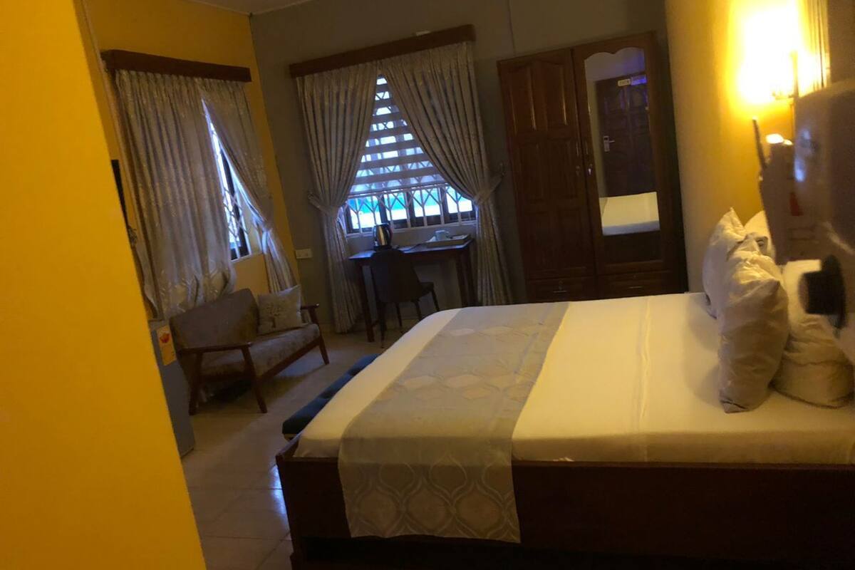 A hotel room with a bed, a desk, and a chair.