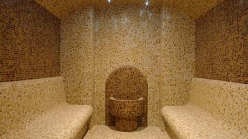 Una habitación con paredes cubiertas de mosaicos y bancos.