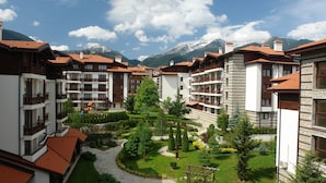 A hotel courtyard with multiple balconies, a playground, and a well-maintained garden.