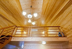 Ein Holzinnenraum mit Deckenventilator, Treppe und Geländer.