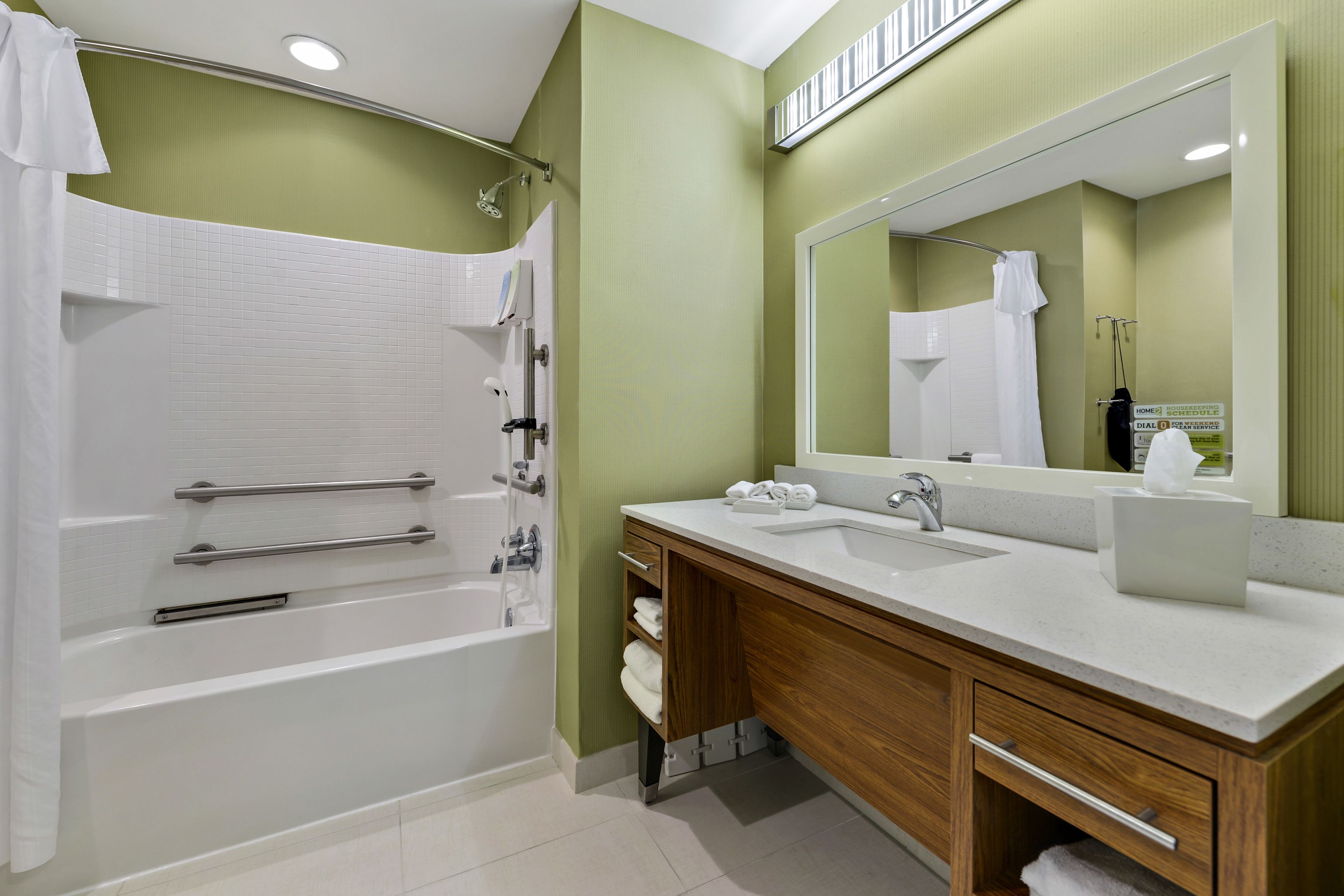 A modern bathroom with a bathtub, a sink, and a vanity.