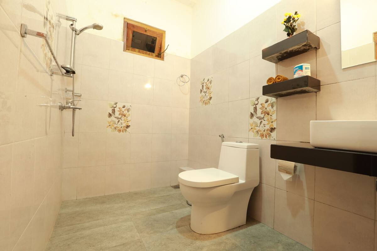 A bathroom with a toilet, shower, and sink.