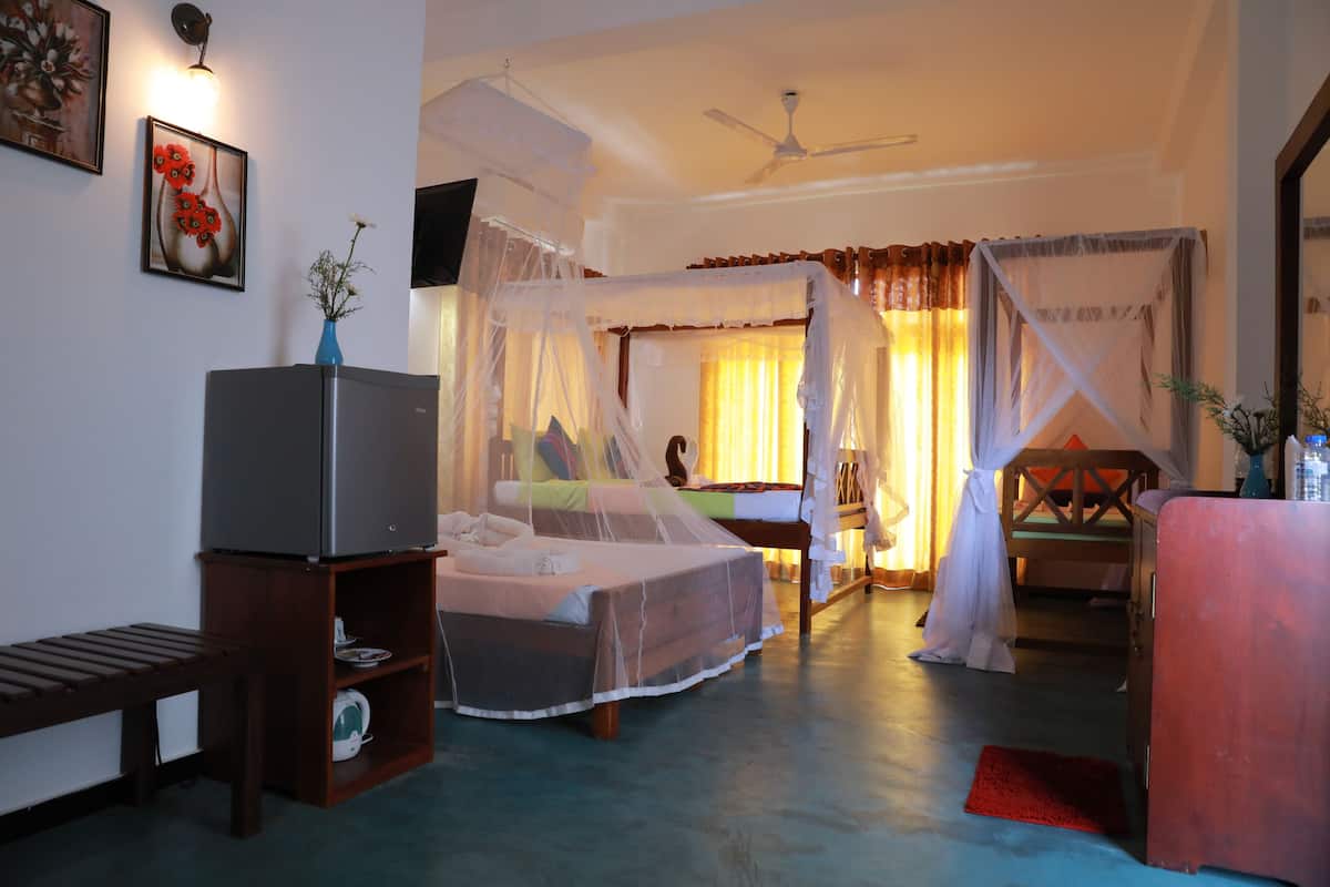A bedroom with a bed, bedside table, and a TV.