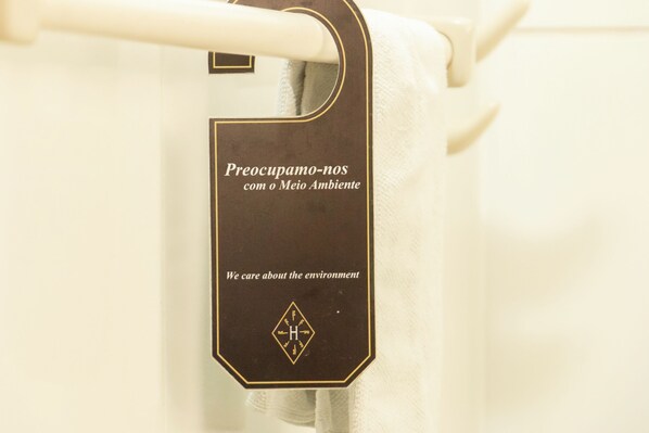 A towel hanging on a rack with a sign that reads "We care about the environment."