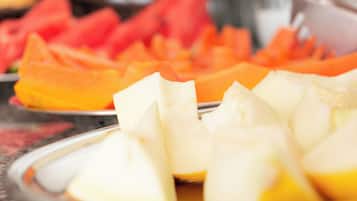 En tallerken med skiveskåret frugt, herunder vandmelon og cantaloupe.