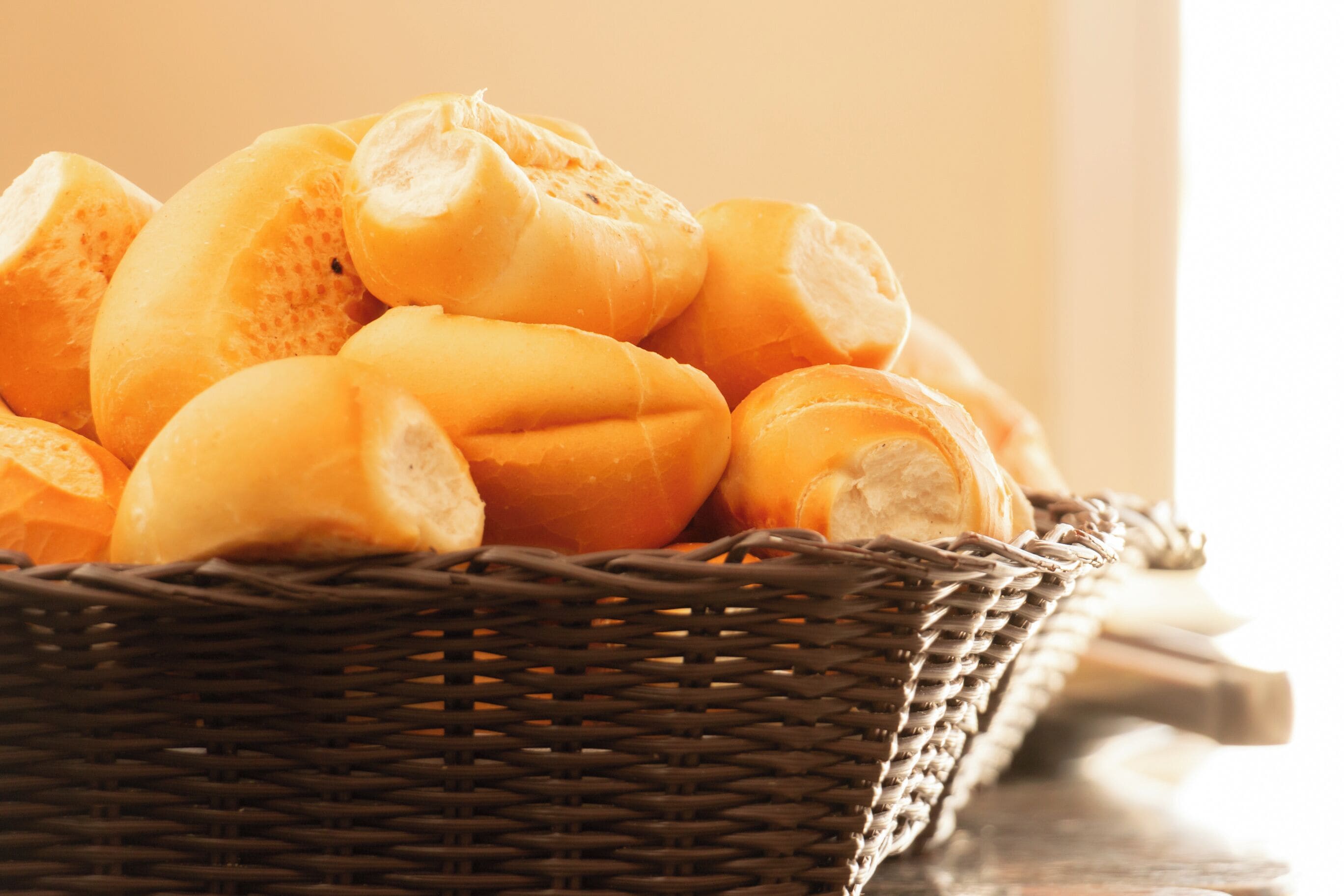 A basket of baguettes on a table.