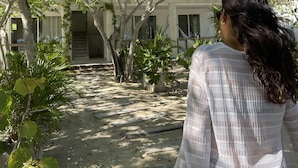 A person standing in a courtyard with a building in the background. - SABAI (Cartagena)