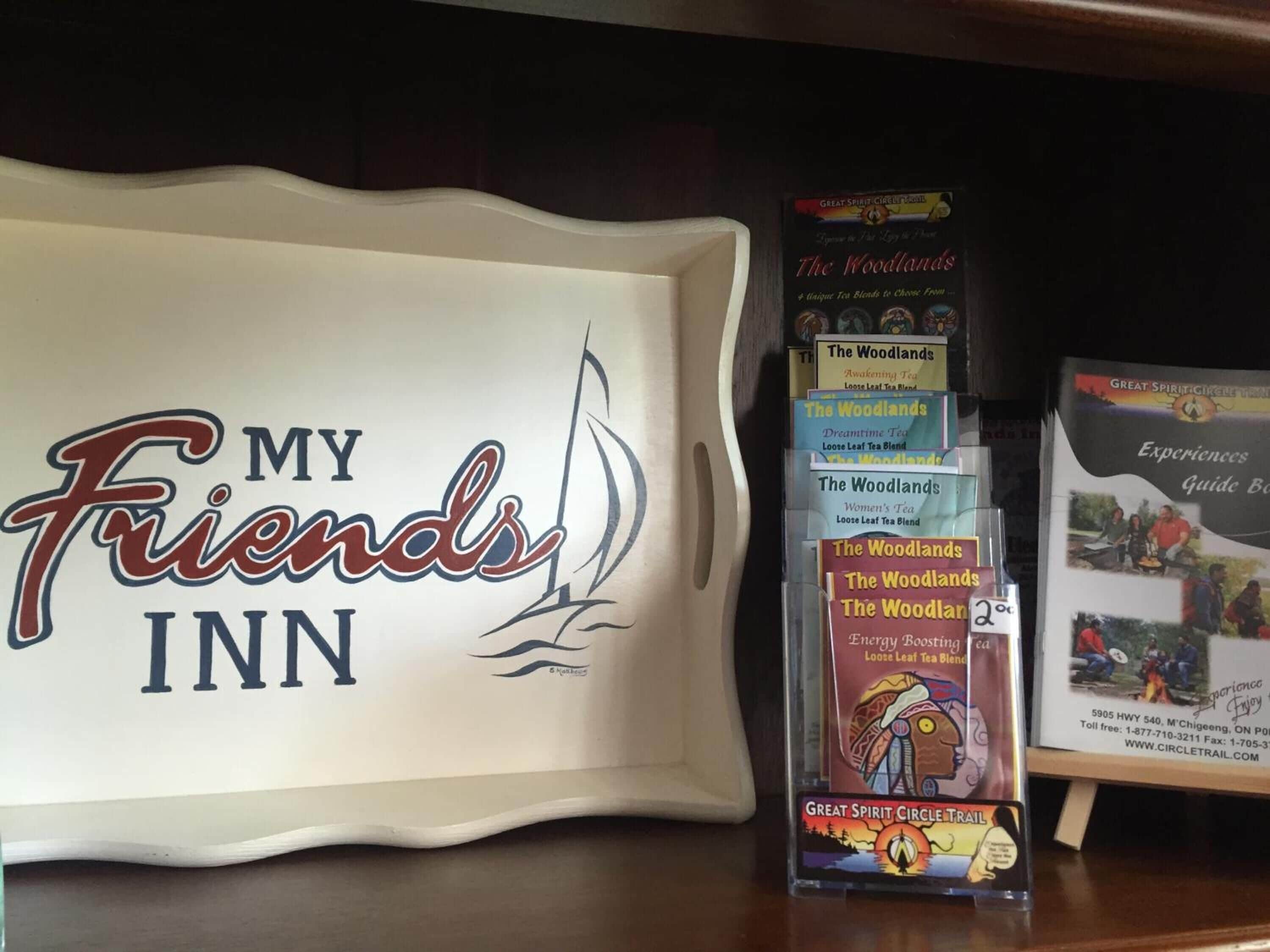 Eine Präsentation von 'The Woodlands' Teesorten und einem Schild mit der Aufschrift 'My Friends Inn'.
