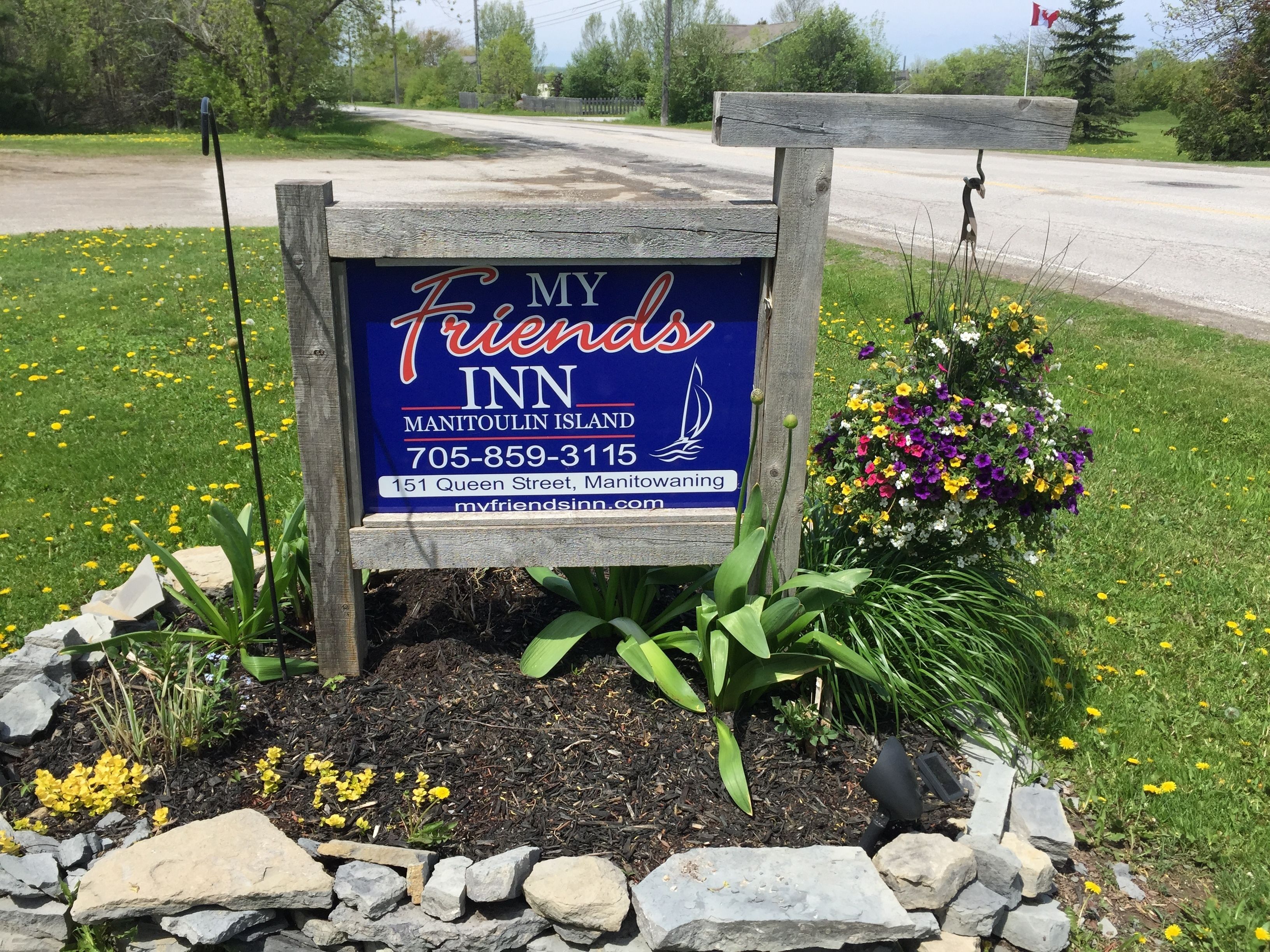 A sign for 'My Friends Inn' on Manitoulin Island with contact details and address.
