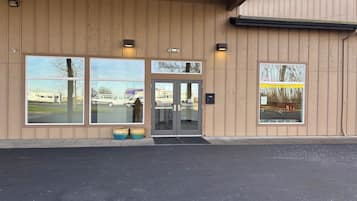 A building with large windows, a door, and two planters.