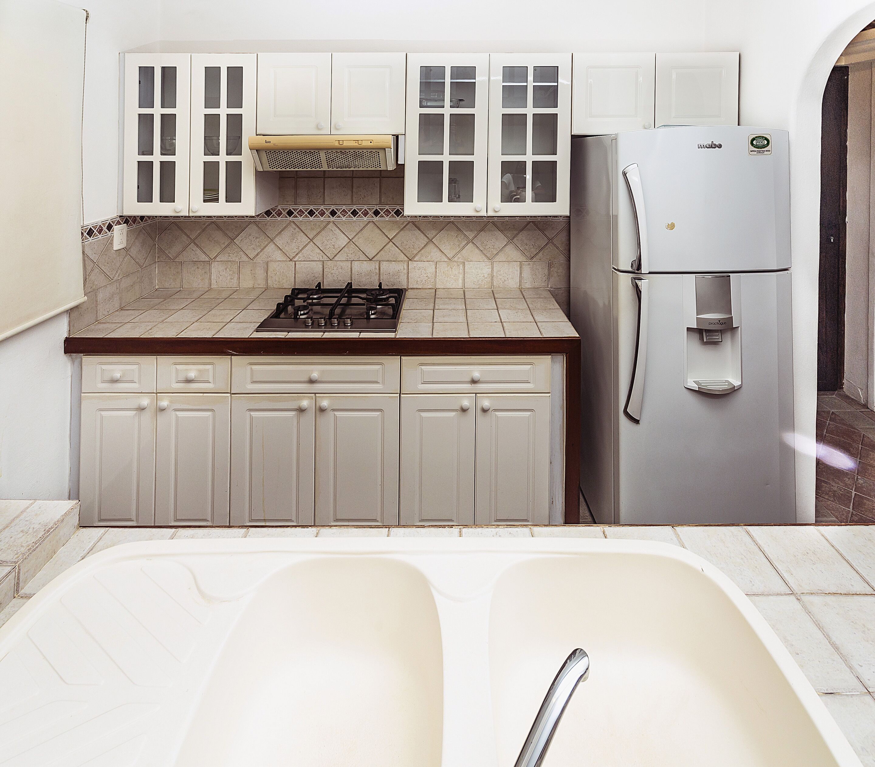 A kitchen with white cabinets, a gas stove, a built-in oven, and a refrigerator.