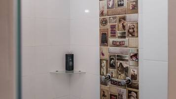 A shower with a rain showerhead and a wall decorated with photographs.