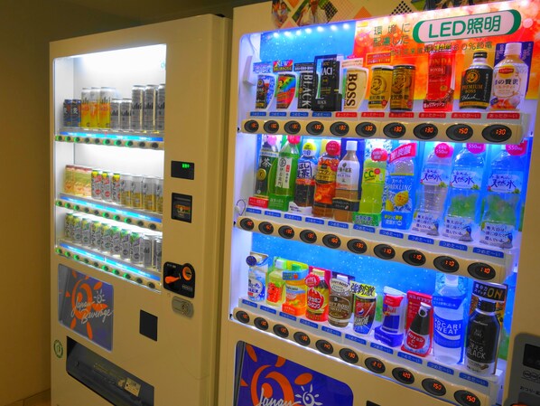 Dos máquinas expendedoras de bebidas con varias opciones y paneles de precios.