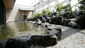 Un aménagement aquatique intérieur paisible, avec un bassin en pierre et une échelle métallique menant à l'eau.