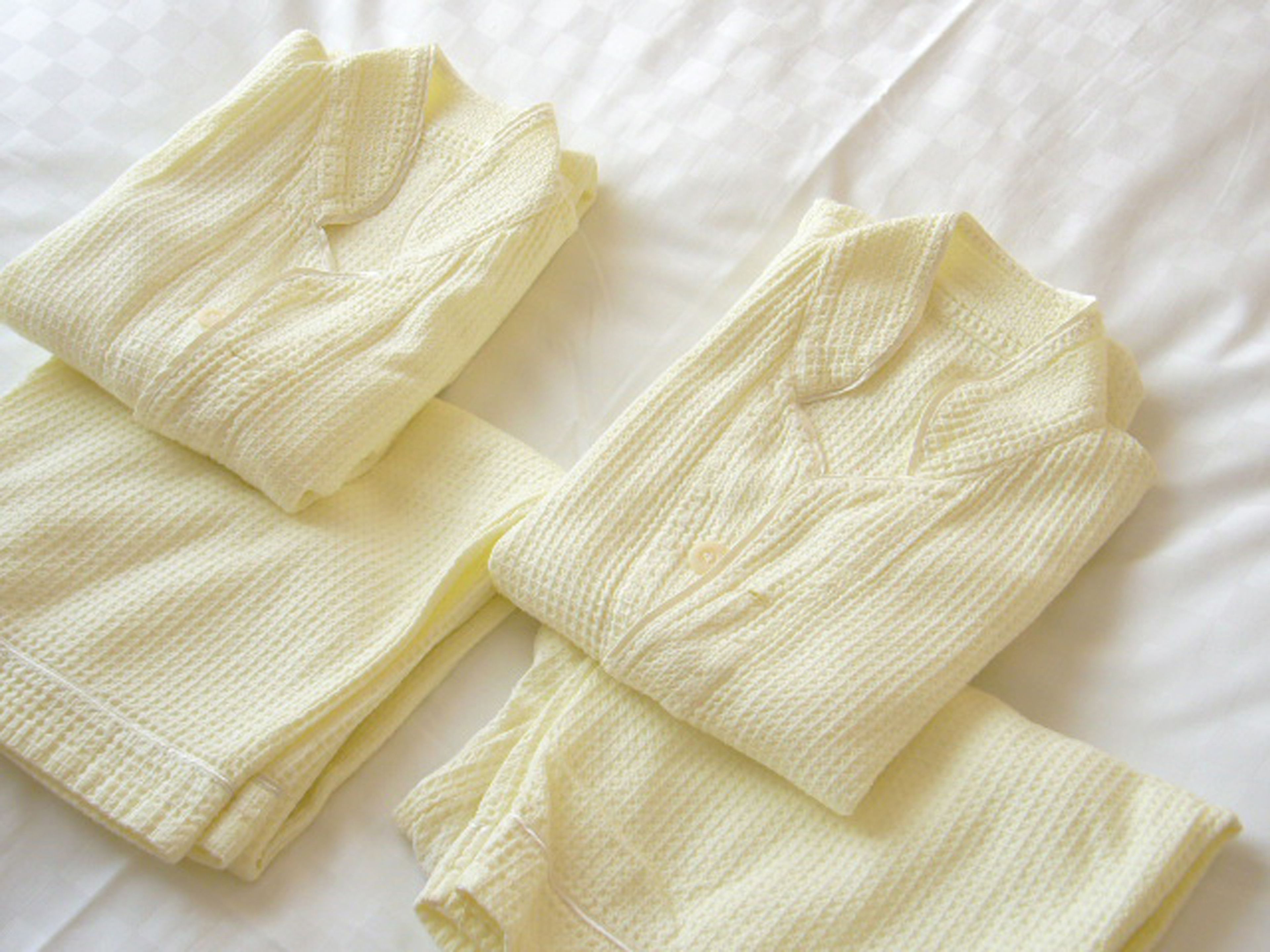 A neatly folded white towel on a bed.