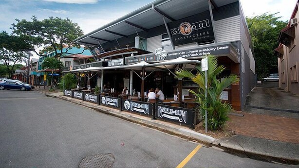 A restaurant with outdoor seating and a sign that reads "Global Backpackers." - Global Backpackers - Port Douglas (Port Douglas)