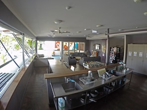 A modern kitchen with a central island, built-in appliances, and a large window offering a view of the outdoors. - Global Backpackers - Port Douglas (Port Douglas)