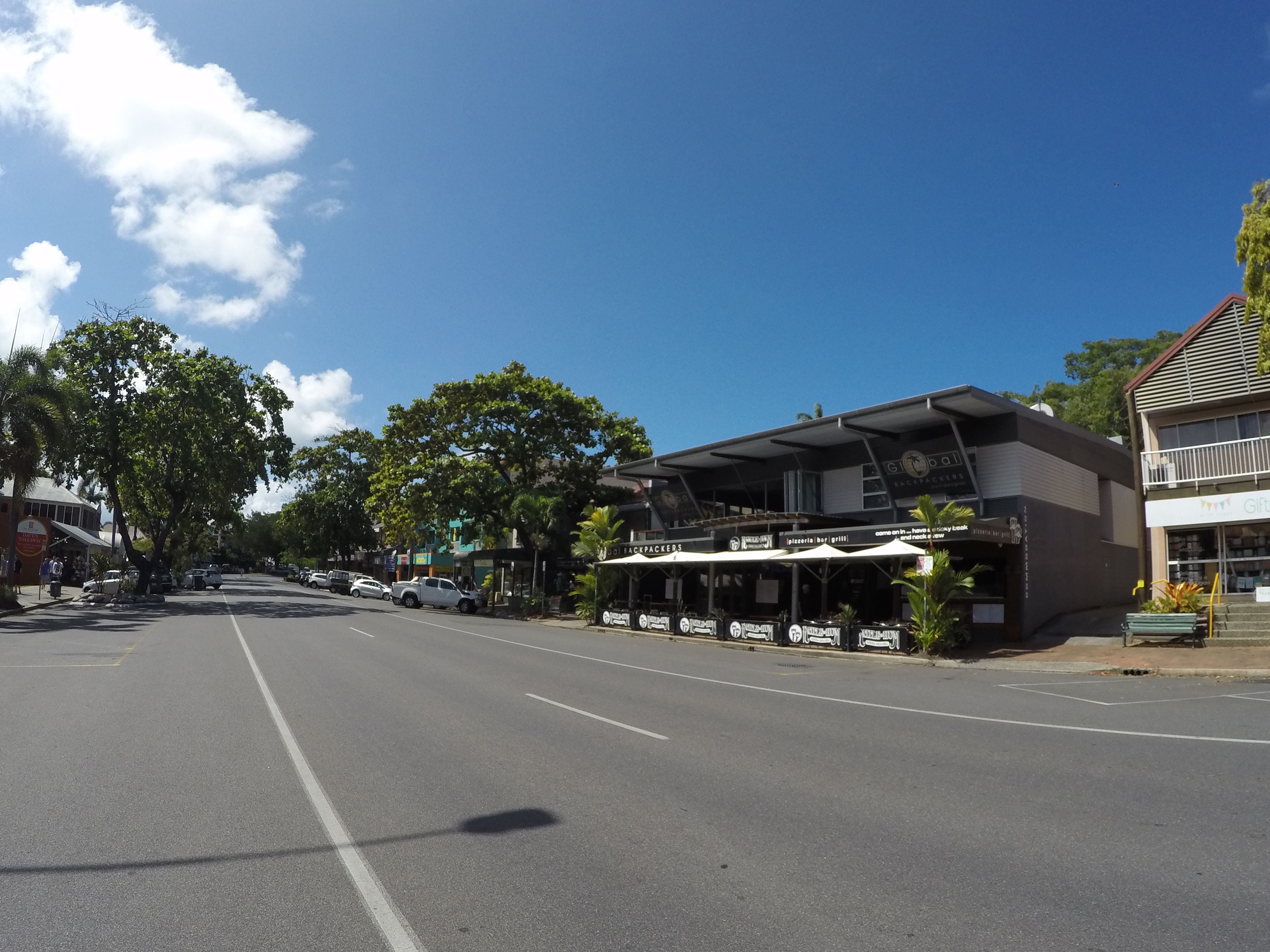 A street view with a building featuring outdoor seating and a sign for 'GOLDBACKER'S'.