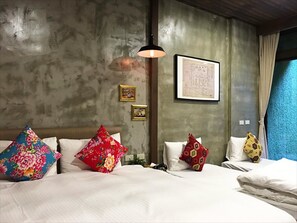 A bedroom with a large bed, multiple pillows, a hanging light, and a framed map on the wall. - Jian Shan Hotel (Taipei)