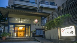 A building with a ramp leading to a door, a sign with Japanese characters, and a potted plant. - Suzuya Konnichiro (Kaga)