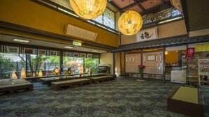 A traditional Japanese inn with tatami mat flooring, wooden furniture, and large paper lanterns. - Suzuya Konnichiro (Kaga)