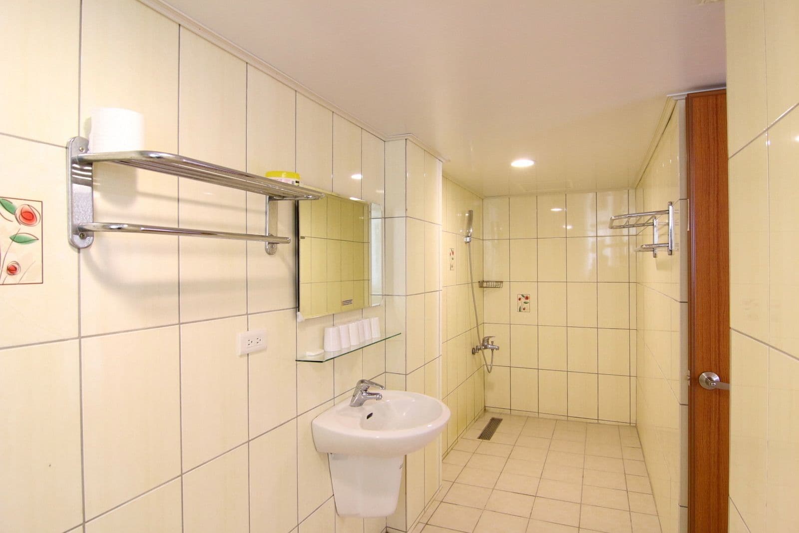 A bathroom with a sink, mirror, and shower.