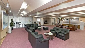 A spacious lounge with leather sofas, a coffee table, and a TV. There is a plant, a desk, and a bulletin board. - Hotel New Ohte (Hakodate)
