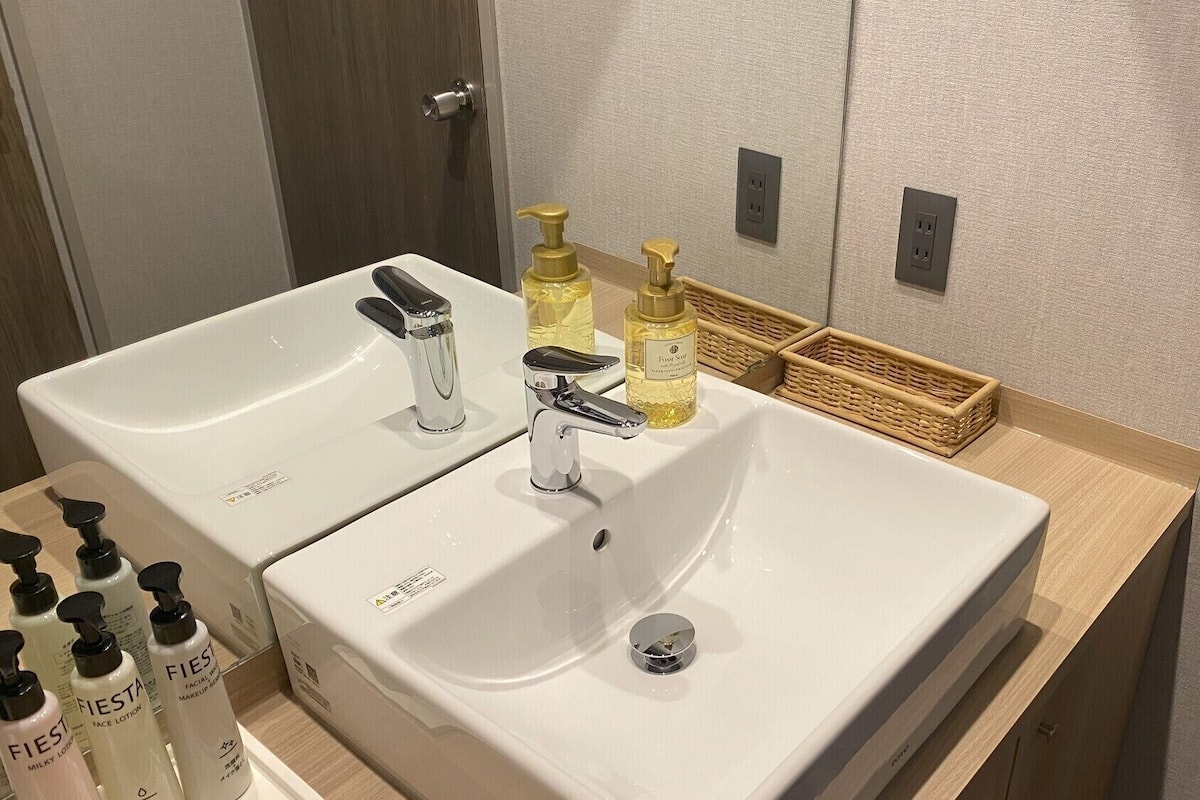 Een badkamer met twee wastafels, een spiegel en toiletartikelen.