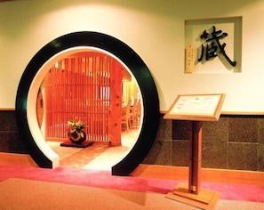 A reception area with a circular wooden frame, a sign with Chinese characters, and a framed certificate on a stand.