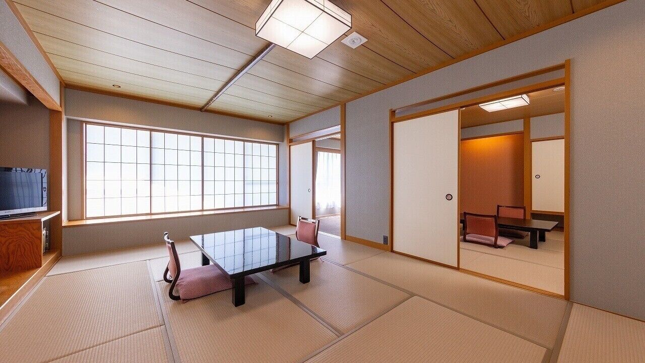 Et traditionelt japansk rum med tatamimåtter, et lavt bord og skydedøre.