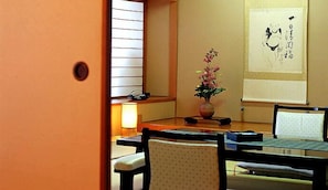 A traditional Japanese room with tatami flooring, a low table, and a shoji screen. - Miya Onsen Higaki Hotel (Gamagori)