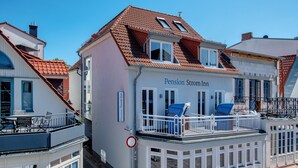 A building named Pension Strom Inn with a balcony, a terrace, and a sign indicating it is a pension. - Pension StromInn (Rostock)