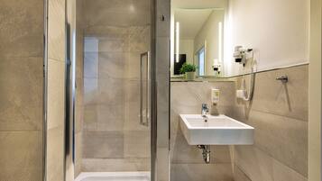 Een bad/douchecombinatie, een haardroger, handdoeken