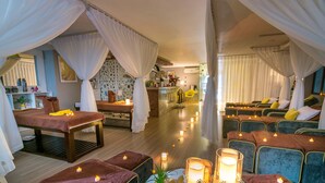 A spa room with massage tables, candles, and a reception area in the background. - Happy Day Riverside Hotel & Spa Danang (Da Nang)