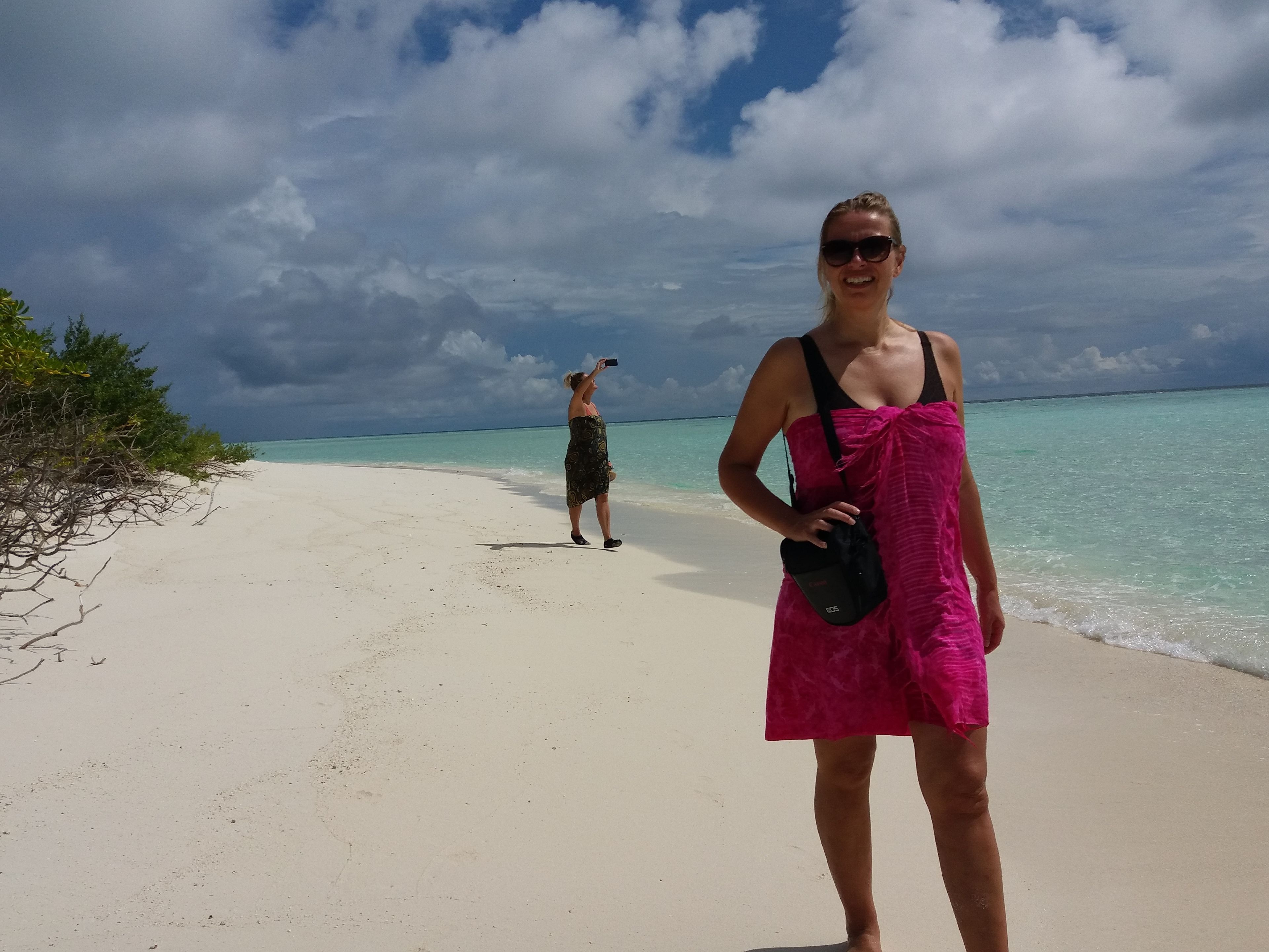 A beach with clear turquoise waters and a sandy shore.