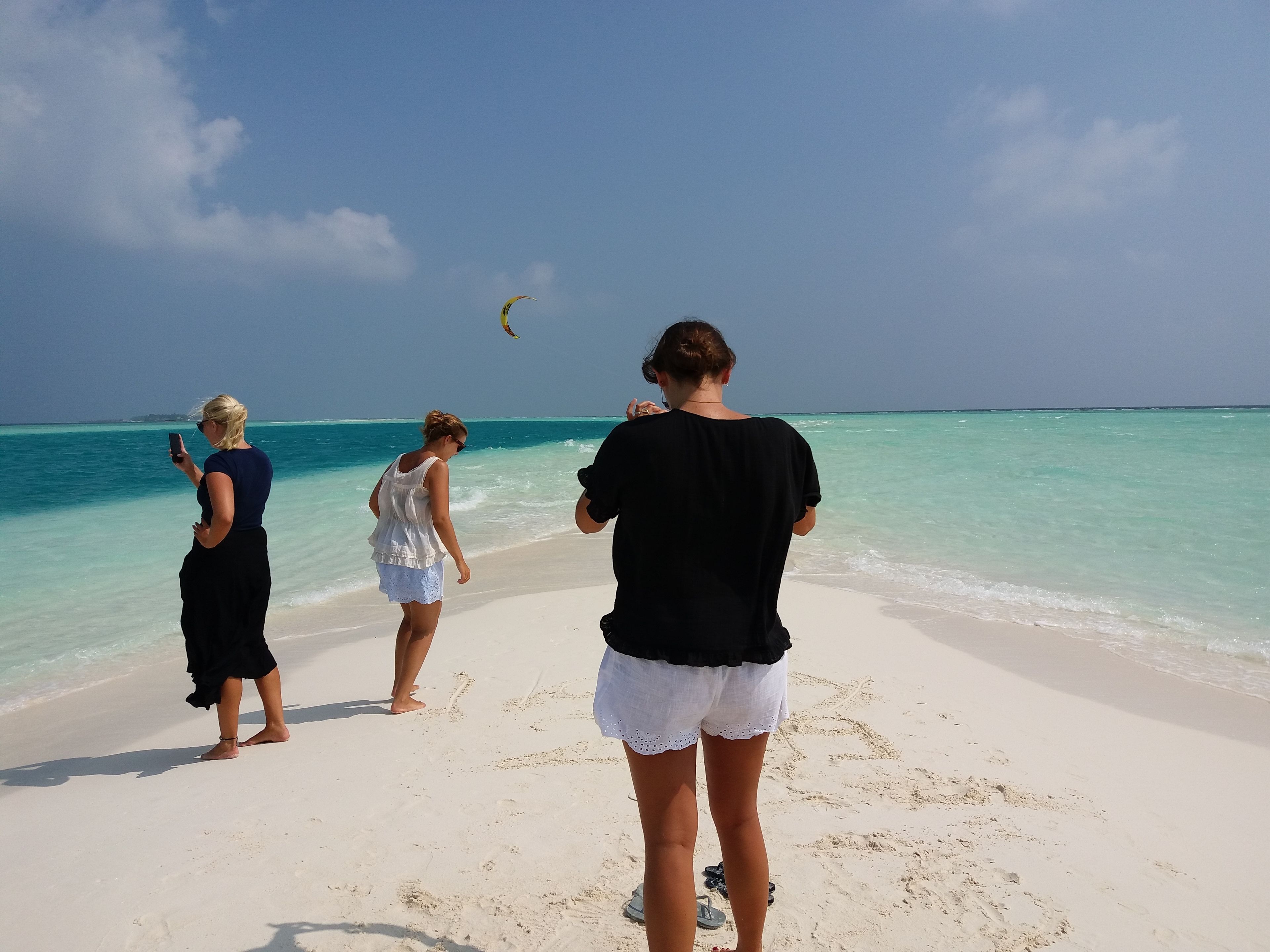 Escena de playa con agua turquesa cristalina y una orilla arenosa.