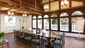 A conference room with a long table, chairs, and a projector screen displaying 'SWISS-CHALET MERLISCHEN'. - Swiss-Chalet Merlischachen - Historik Chalet-Hotel Lodge (Kuessnacht)