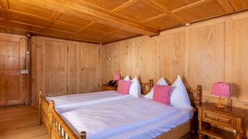 Una habitación con paneles de madera, una cama grande, dos mesitas de noche y un armario de madera.